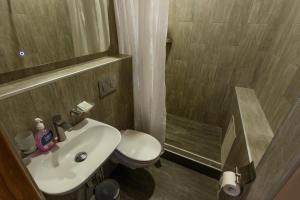 y baño con aseo, lavabo y ducha. en Koisha en Bishkek