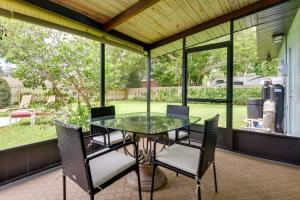 a glass table and chairs on a screened in porch at Uncle Louies Gulf Coast Retreat with Outdoor Oasis! in Bradenton
