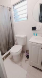 a white bathroom with a toilet and a sink at Urban Lodgings Two @ Roosevelt 457 in San Juan