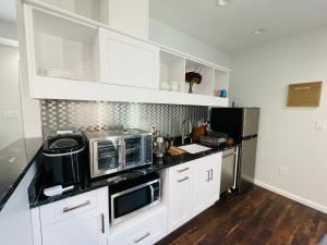 uma cozinha com armários brancos e um micro-ondas em Sonsak - Unit 2 em Charlottesville