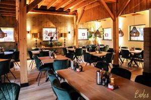 uma sala de jantar com mesas e cadeiras de madeira em Vakantiehuis de Bakspieker em Haaksbergen