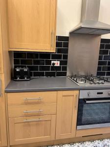 a kitchen with wooden cabinets and a stove top oven at Luxury Victorian spacious flat in Glasgow