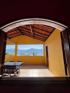 a room with a table and a view of the mountains at Alto do Marinas in Angra dos Reis