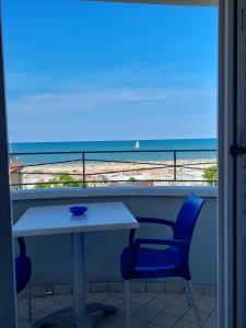 a table and chairs with a view of the beach at Residence Saturnia in Riccione