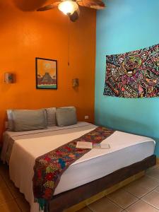 a bedroom with a bed with a painting on the wall at The Grateful Hotel in Playa Grande