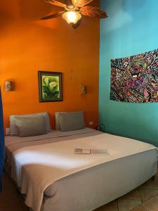 a bedroom with a bed with a painting on the wall at The Grateful Hotel in Playa Grande