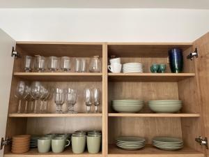 a wooden cabinet filled with dishes and glasses at Spacious apartment near the city centre in Bratislava