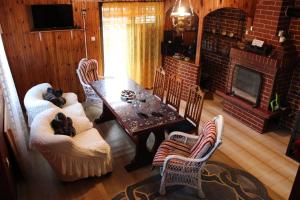 - un salon avec une table, des chaises et une cheminée dans l'établissement Vikendica "Oaza mira", à Gacko