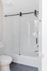 a white bathroom with a tub and a toilet at Fire Station One Boutique Hotel in Roanoke