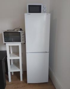 a microwave sitting on top of a refrigerator next to a stove at W13 x Weekly Monthly Discount in London