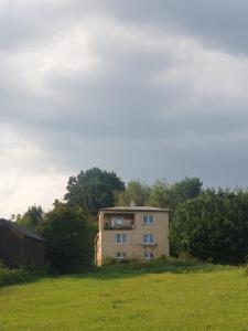 a building in the middle of a grass field at Snina studio apartment in Snina
