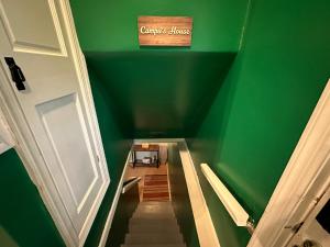 uma sala verde com escadas e um sinal na parede em Campu’s Basement Studio w/ private entrance em Cherry Hill