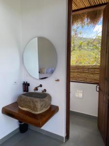 baño con lavabo y espejo en la pared en Summer C en Macanal