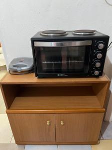 a black microwave sitting on top of a wooden cabinet at Traditional Lemon House near to Pireaus Port in Piraeus