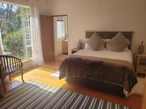 Un dormitorio con una cama grande y una ventana grande. en Eden Guesthouse, en Johannesburgo