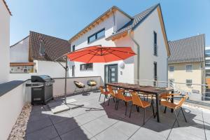 a patio with a table and chairs and an umbrella at Golden Home with Barbecue, Yoga, Football Table in Sinsheim