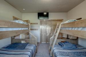 two bunk beds in a room with a television at Holy Terror Chalet At Terry Peak Ski Resort in Lead
