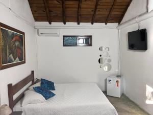1 dormitorio pequeño con 1 cama y TV en Pousada Estalagem Paraty, en Paraty