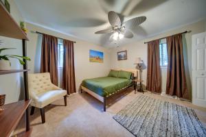 a bedroom with a bed and a chair and a ceiling fan at Richmond Heights Retreat with Patio and Fire Pit! in Richmond Heights