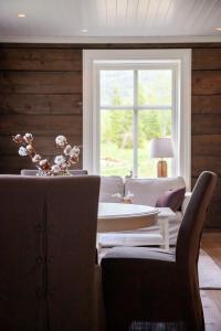 a living room with a table and chairs and a window at Tuftegarden in Viksdalen