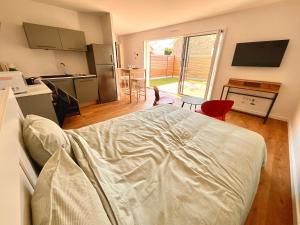 a bedroom with a bed and a kitchen with a table at Charmant studio Pornicais in Pornic