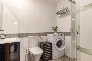 a bathroom with a washing machine and a washer at Flor do Mar - Spacious Apartment with Balcony in Vila Praia de Âncora