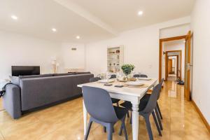 a dining room with a table and chairs and a couch at Flor do Mar - Spacious Apartment with Balcony in Vila Praia de Âncora