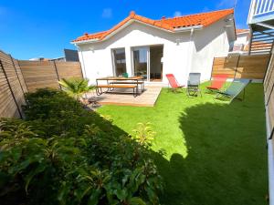 a backyard with a picnic table and chairs at Charmant studio Pornicais in Pornic