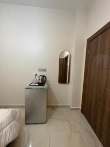 Habitación con cama y espejo en la pared. en Jasmine flower hostel en Madaba