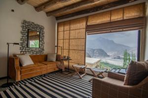 a living room with a couch and a large window at BROQ in Skardu