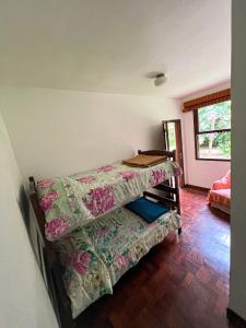 a room with a bed with a table on it at Chale das hortensias in Petrópolis