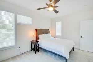 a white bedroom with a bed and a ceiling fan at Modern Lawrence Home with Patio Less Than Half-Mi to U of K! in Lawrence