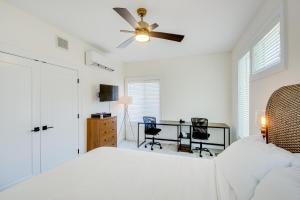 a bedroom with a bed with a ceiling fan and a desk at Modern Lawrence Home with Patio Less Than Half-Mi to U of K! in Lawrence