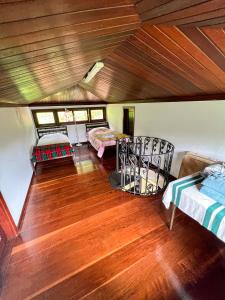 Habitación con 2 camas y suelo de madera. en Chale das hortensias, en Petrópolis