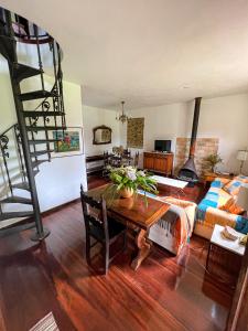 uma sala de estar com uma mesa e uma escada em espiral em Chale das hortensias em Petrópolis