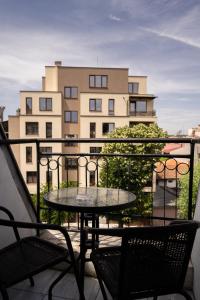 einen Tisch und Stühle auf einem Balkon mit einem Gebäude in der Unterkunft Jeweller Hotel in Ruse