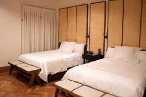 Cuatrociénegas de CarranzaにあるHotel Marielenaのベッド2台とテーブルが備わるホテルルームです。