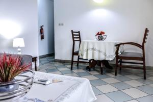 Tchero Appartement 1 في دوالا: غرفة طعام مع طاولة وكراسي