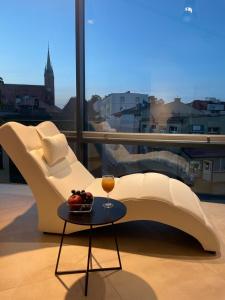 een witte bank en een tafel met een glas wijn bij Apartament III w Centrum - Winda - 50 metrów od Starego Rynku in Kościerzyna