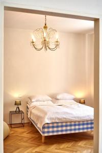 a bedroom with a bed and a chandelier at Apartmán III Praha - centrum in Prague