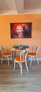 a table and chairs with a painting on the wall at Czas relaksu in Jedlina-Zdrój