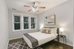 ein weißes Schlafzimmer mit einem Bett und zwei Fenstern in der Unterkunft Modern & Furnished 2BR Apt with In-unit Laundry - Sunnyside 2E in Chicago