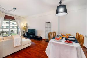 un soggiorno con un tavolo e un divano bianco di Ocean Front 2bed Luxury w/ Elevator Parking WI-FI a Matosinhos