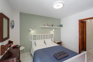 - une chambre avec un grand lit et une couverture bleue dans l'établissement One-bedroom with views of Los Gigantes, à Santiago del Teide