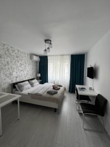a bedroom with a bed and a table and a chair at Kenzia Prive in Bucharest