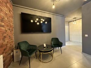 a room with two chairs and a table and a tv at elisio - Bricks Apartment in Braşov