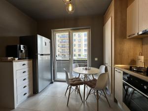 a kitchen with a table and chairs and a window at elisio - Bricks Apartment in Braşov