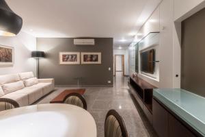 A television and/or entertainment centre at DELPLAZA Excelsior São Paulo - By Monreale