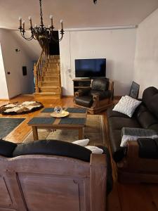 een woonkamer met een bank en een tv bij Dom w górach in Koszarawa