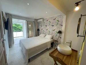 a bedroom with a large white bed and a window at Les Appart villa Sunbay Caraibes avec piscine privative vue mer et montagne in Le François